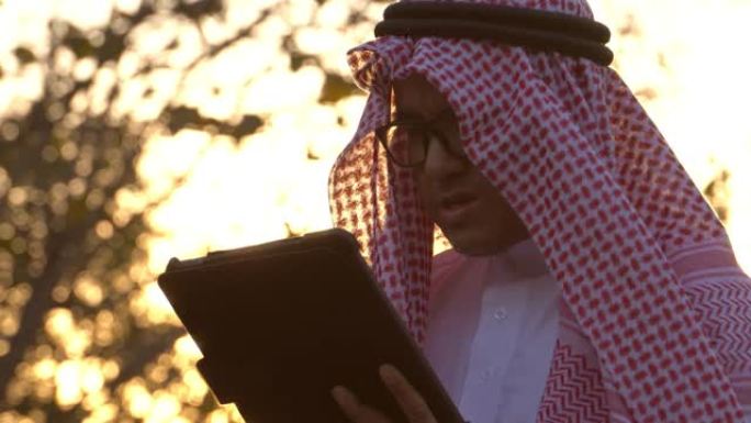 一名阿拉伯男子正在用平板电脑监控自己的石油业务
