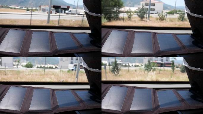在城市的背景下，从窗户的几个部分折叠旅游太阳能电池板。