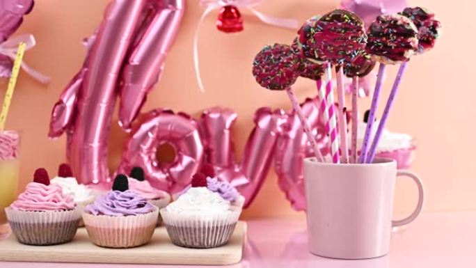 甜桌的特写镜头，配有派对和庆祝活动的甜点。杯子蛋糕、蛋糕和气球布丁