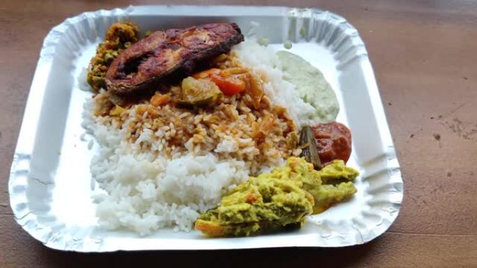 美味的新鲜喀拉拉邦食物米饭，咖喱和鱼苗放在一个孤立在表面上的盘子里