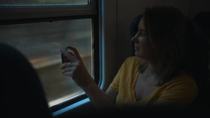 女人拍摄她在火车内旅行的视频。