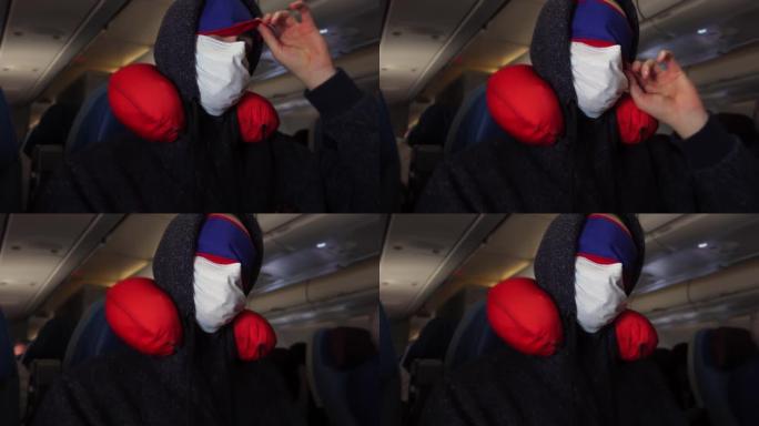 戴着医用口罩和眼圈绷带的男性游客正试图在带颈枕的飞机沙龙中放松