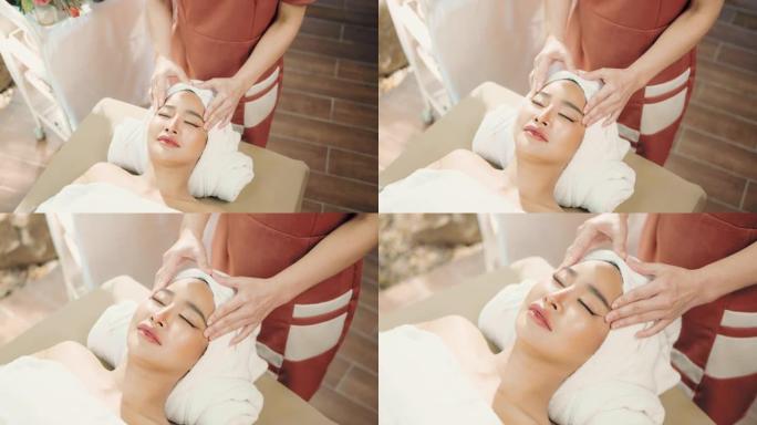 亚洲美丽的女性在水疗中心享受放松的面部护理