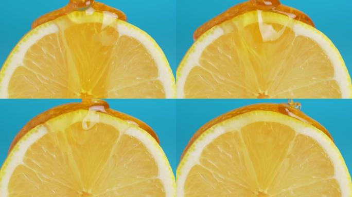蜂蜜从蓝色背景上的新鲜柠檬片上滴下来的宏观纹理照片。