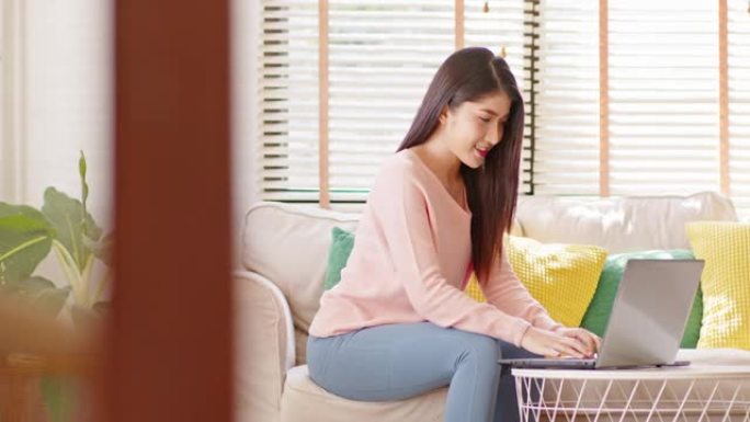 企业家美丽的商业亚洲年轻女子穿着粉色毛衣在家用笔记本电脑在线工作。自由女性在线销售营销，在家在线购物