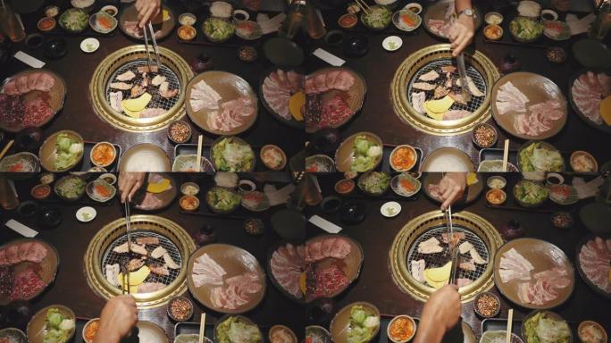 俯视图人们喜欢在桌子上烧烤猪肉和牛肉烤肉串，日本午餐套餐