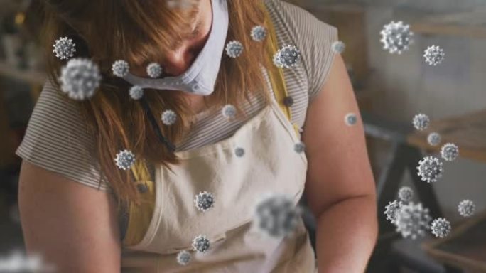在陶器工作室工作的妇女戴着口罩的covid 19细胞动画