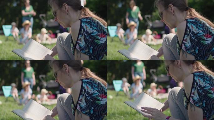 戴着墨镜的女人在公园集体旅行时坐在草地上看书