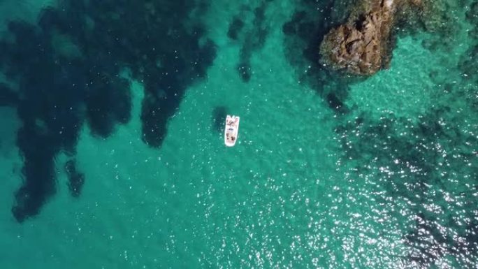 与朋友一起在巴利阿里群岛的绿松石水中度假的小型租赁船
