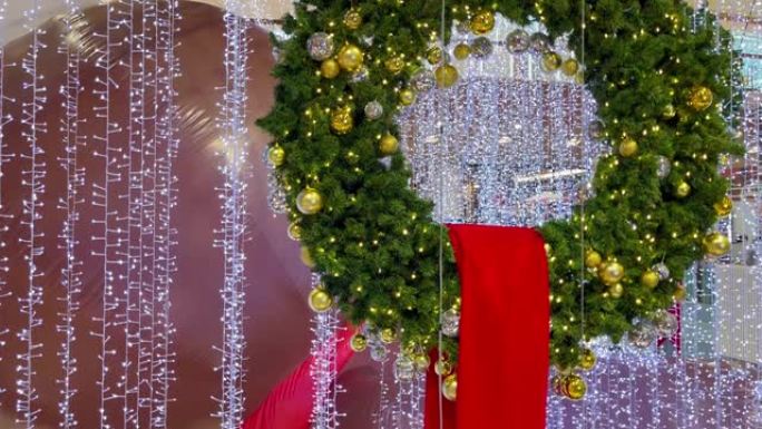 购物中心带有金色球和白色灯串的圣诞绿色皇冠