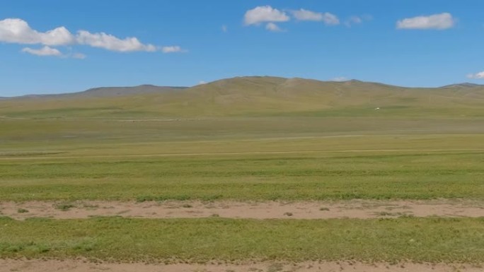 穿越开阔的草原和雄伟的蒙古山脉。乡村山水有山，蓝天有云。