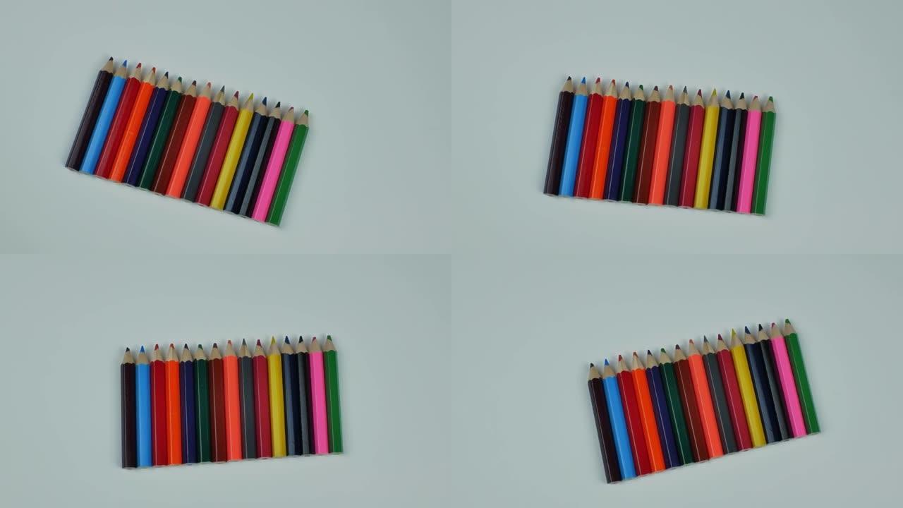 浅色背景上的一组多色木制铅笔。一组彩色木制铅笔排成一排。平躺，从上面看正视图。一套绘画铅笔的概念