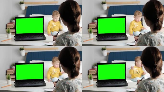女人坐在卧室的桌子上，看着笔记本电脑的绿屏，通过互联网视频通信与某人交谈，有时在笔记本上做笔记。背景