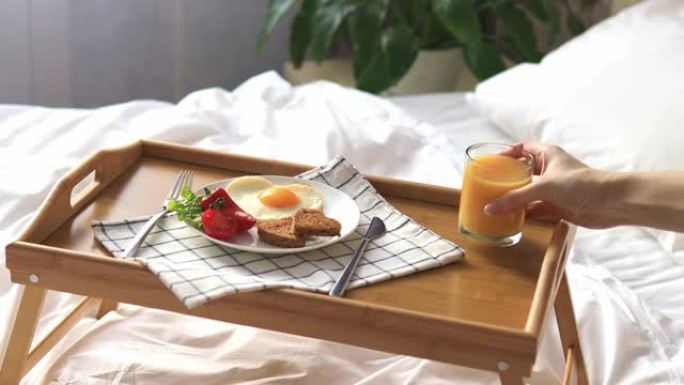 在床上的托盘上吃早餐。早。心形蔬菜煎蛋。
