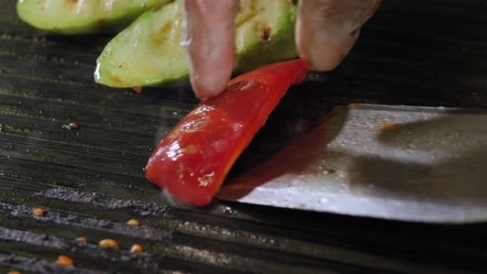 厨师烧烤蔬菜的特写镜头-番茄，西葫芦和红辣椒。