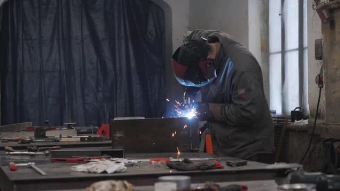 防护面罩中的一名工人焊接金属零件