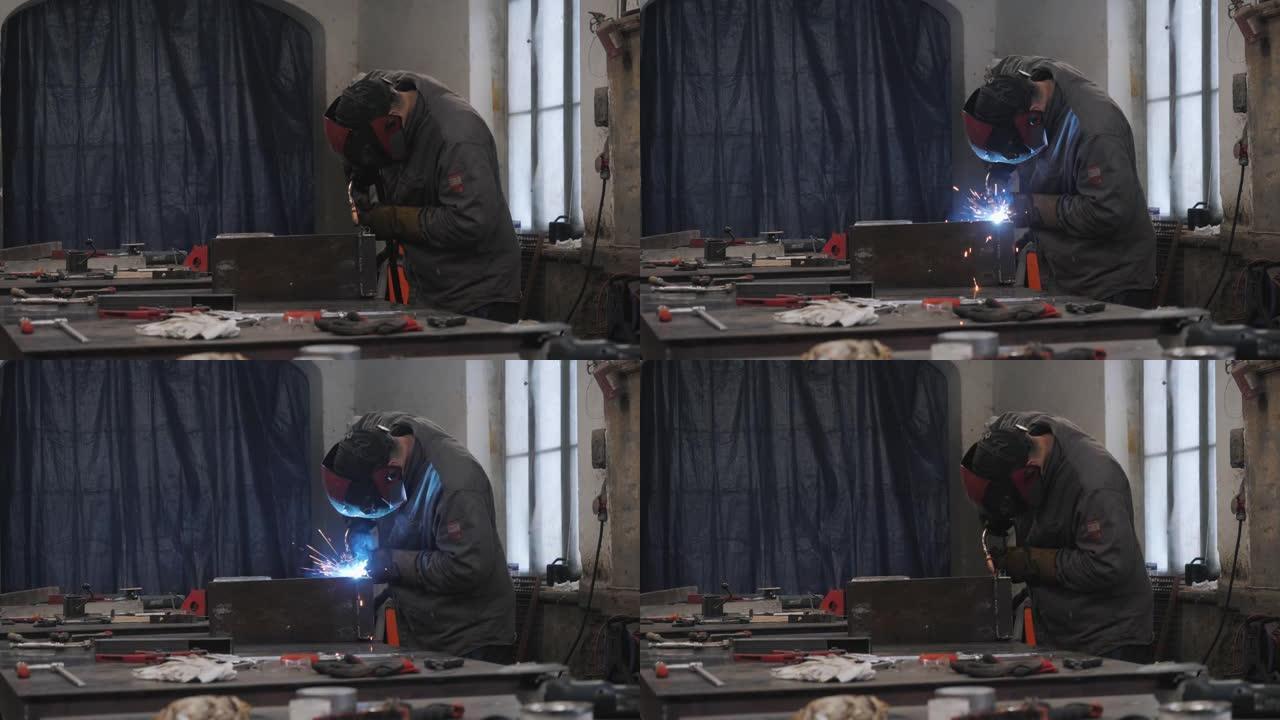 防护面罩中的一名工人焊接金属零件