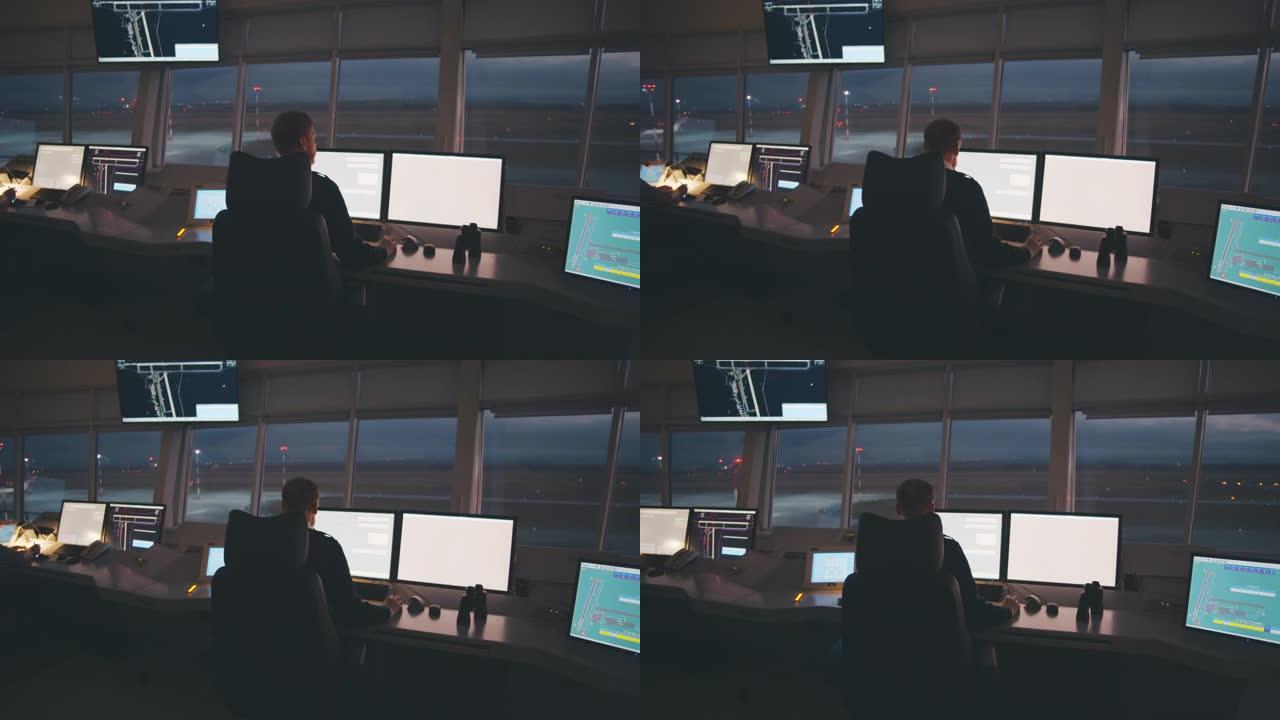 调度员坐在办公桌前，多台显示器在现代交通控制中心工作。实时