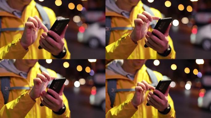 男性快递员在夜间街头通过互联网在手机中寻找信息特写4k电影慢镜头