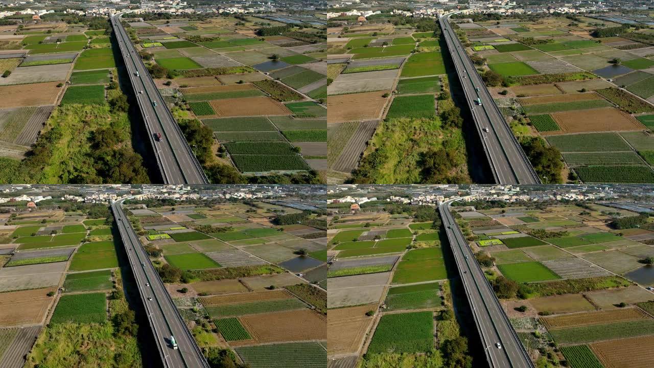 在高速公路路口行驶的汽车的鸟瞰图。连接建筑概念的绿色花园和树木的桥梁道路。