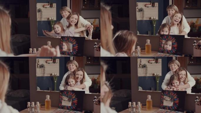 一个幸福家庭的三代女人，一个老奶奶，一个小女儿和一个小女孩在镜子前拥抱，微笑，大笑。生动的情感。一个