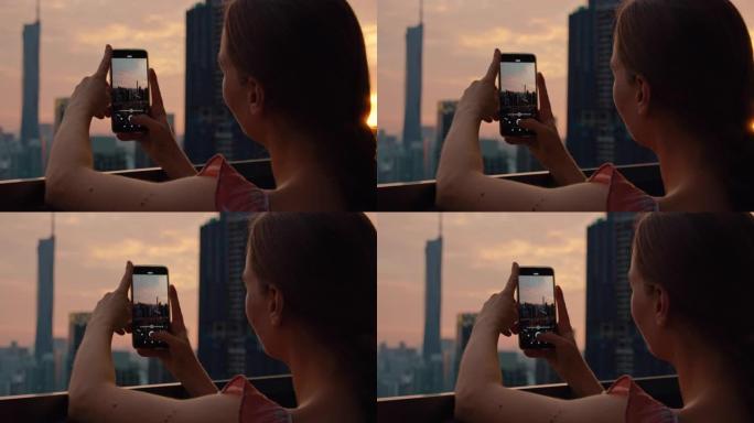 女孩用手机记录巨大的现代城市吉隆坡与默迪卡118日落太平洋粉红色光的视频。黄昏的特写镜头。孤独女人的