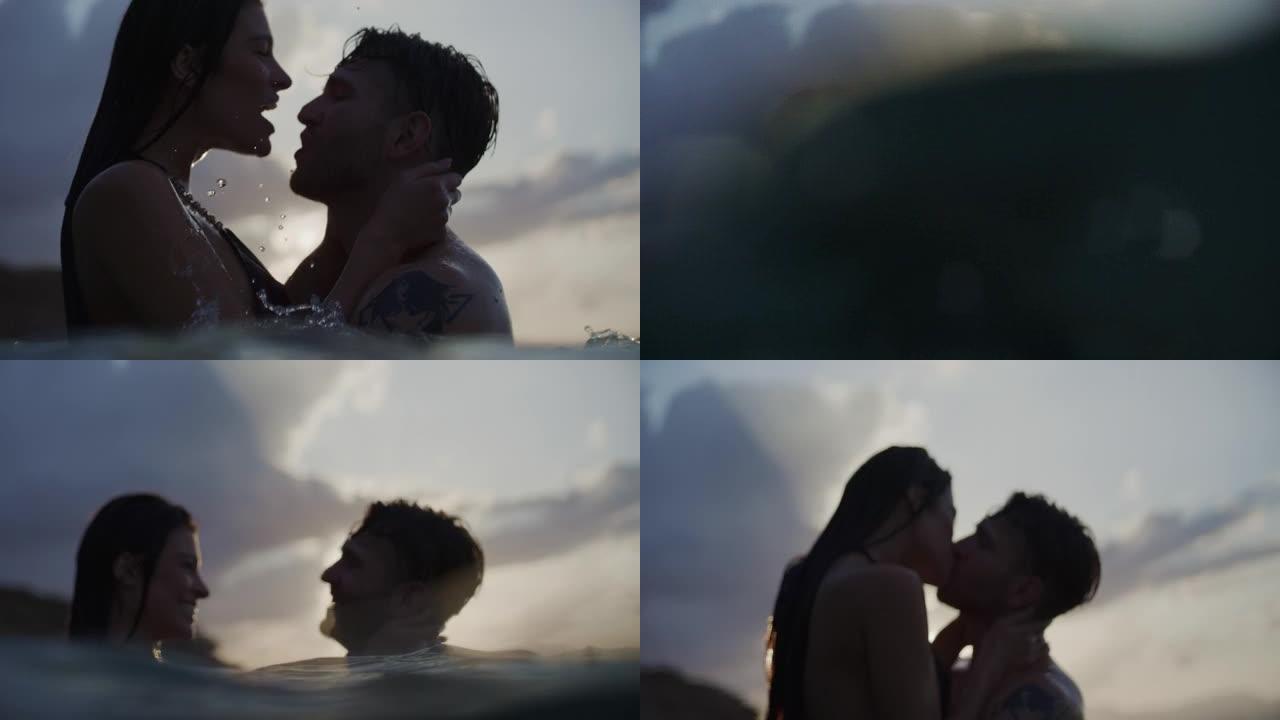 浪漫的异性恋夫妇在金色日落时在海里游泳。在水中接吻和拥抱