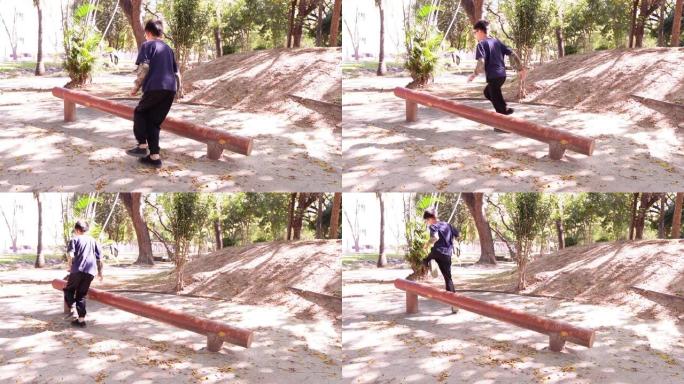 一个小男孩在公共健身公园展示了一项跳过原木训练腿部和脚踝肌肉的运动的慢动作视频片段。