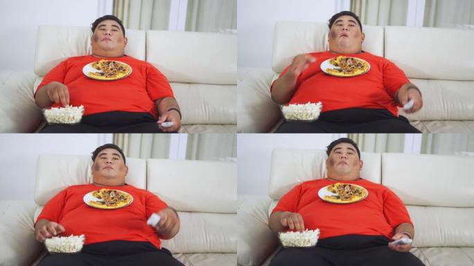 肥胖男子在家吃零食时看电视