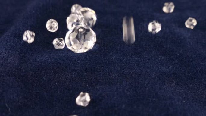 透明的白色珠宝水晶和水钻落在蓝色天鹅绒上。