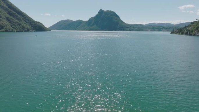 在夏季晴朗的天空中飞越高山湖泊