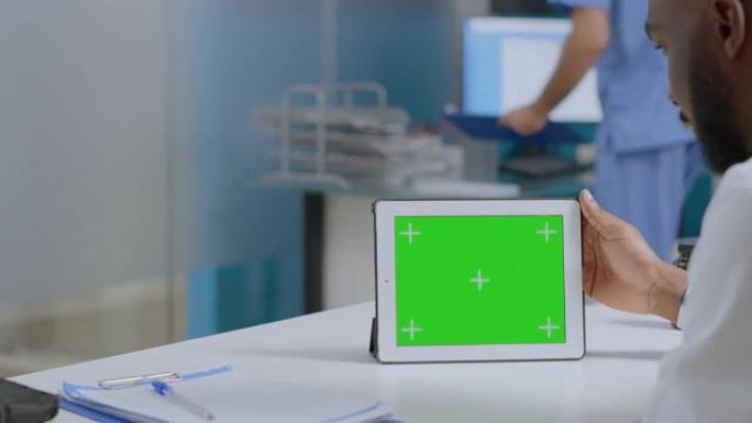 非裔美国男子医生分析疾病诊断报告手持模拟绿屏平板电脑