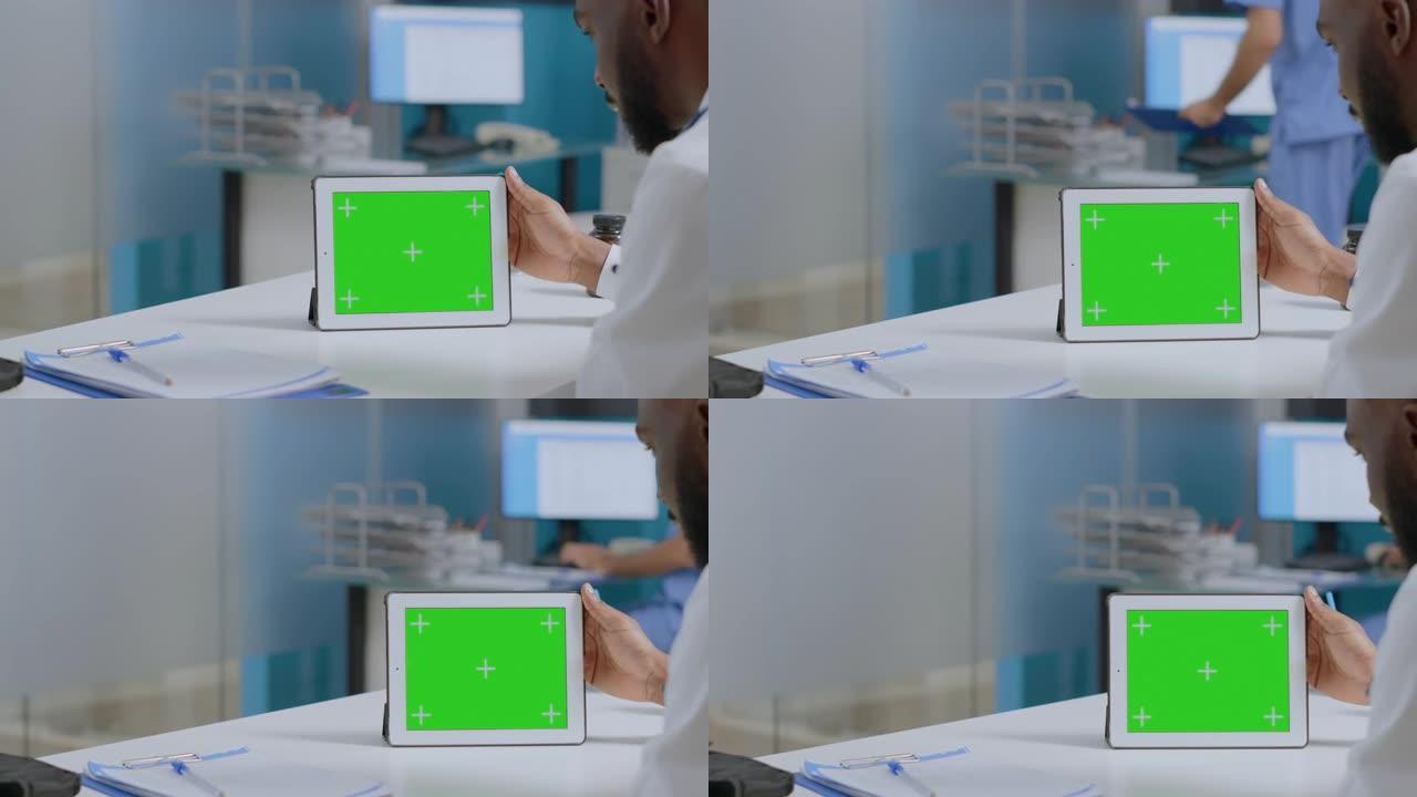 非裔美国男子医生分析疾病诊断报告手持模拟绿屏平板电脑