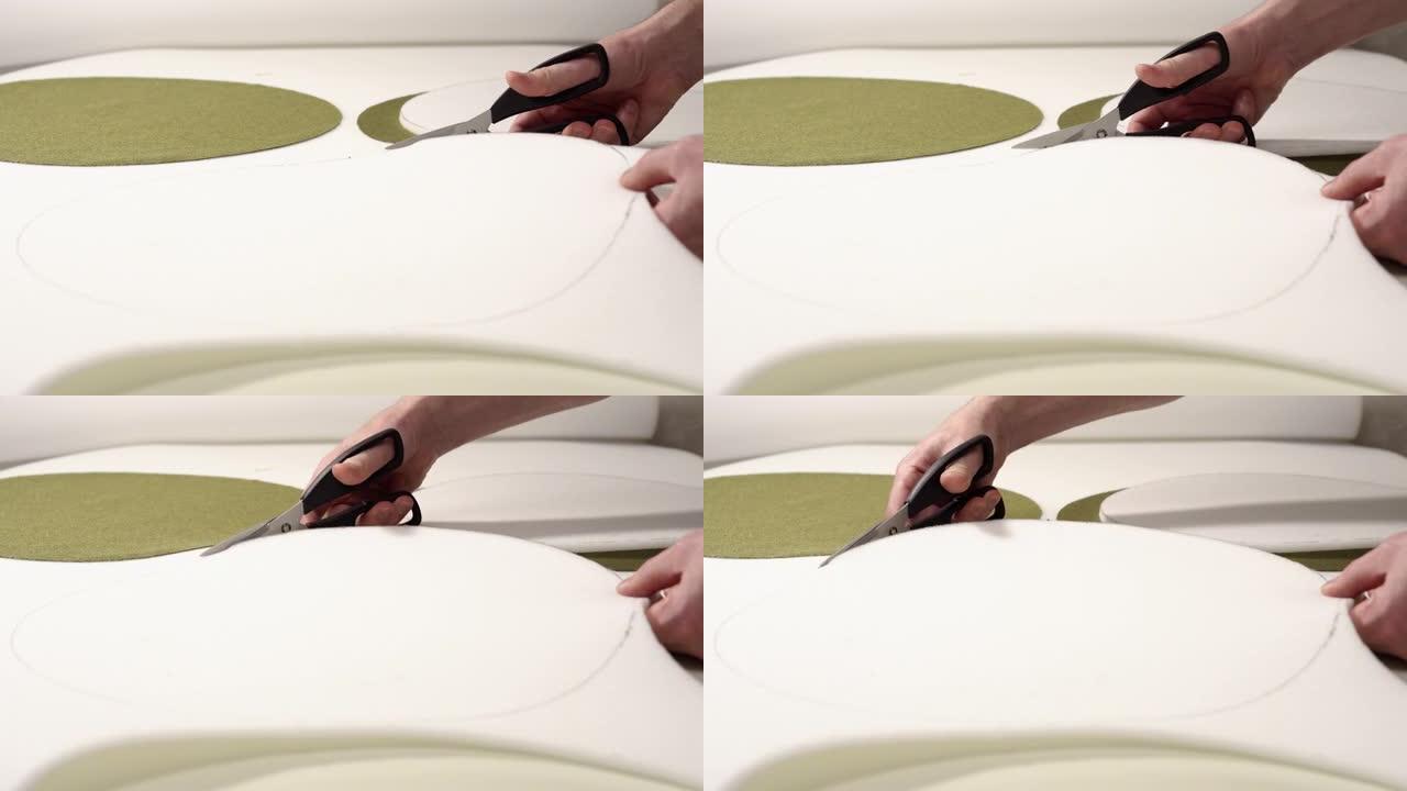 家具修复。一名男子从泡沫橡胶中切出细节，用于装饰家具。特写手