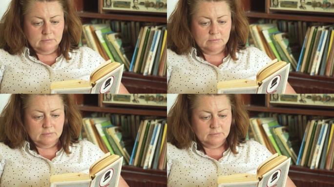 一个胖女人在书柜的背景下坐在扶手椅上看书。孤独和遗弃。对自己的失望