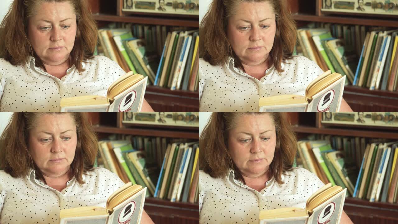 一个胖女人在书柜的背景下坐在扶手椅上看书。孤独和遗弃。对自己的失望