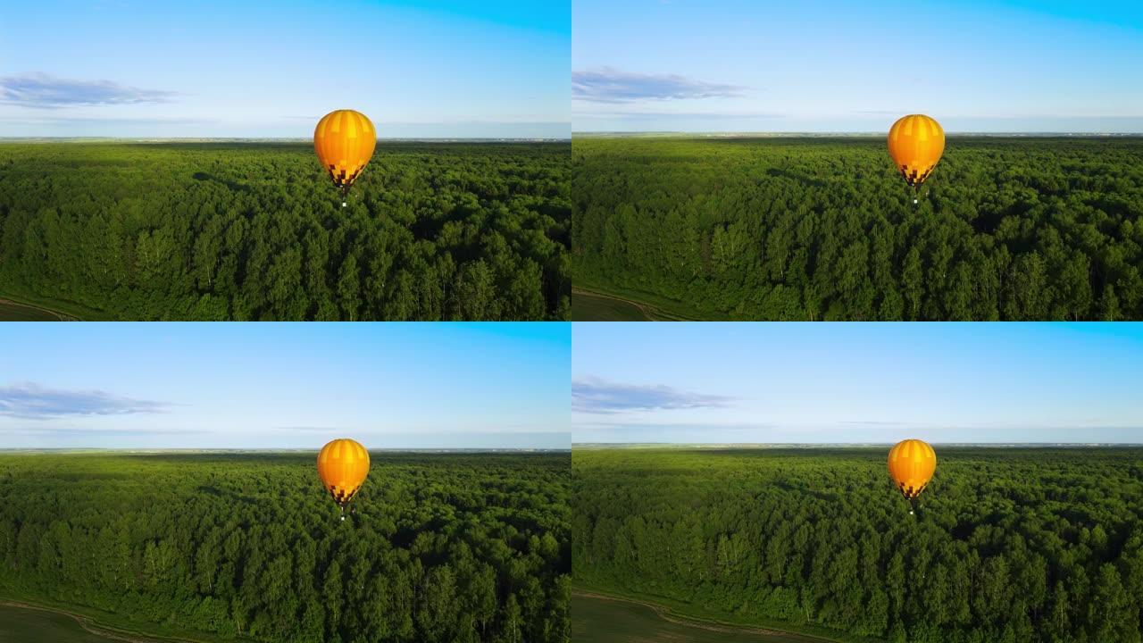 一个黄色的尼龙气球飞过森林。丙烷燃烧器喷出火焰