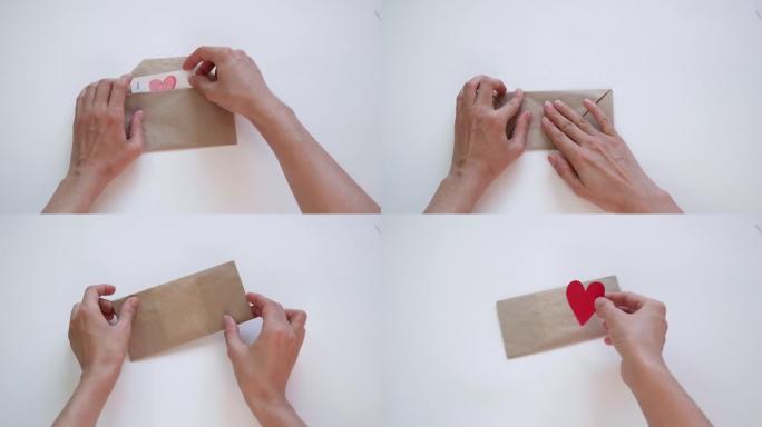 双手打开一个信封，在情人节那天放一个红色的心形情人节。爱情宣言，关系概念