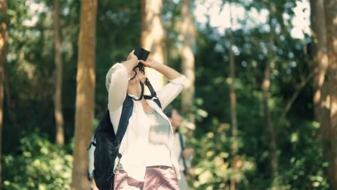 老年妇女使用双筒望远镜在森林中寻找鸟类。