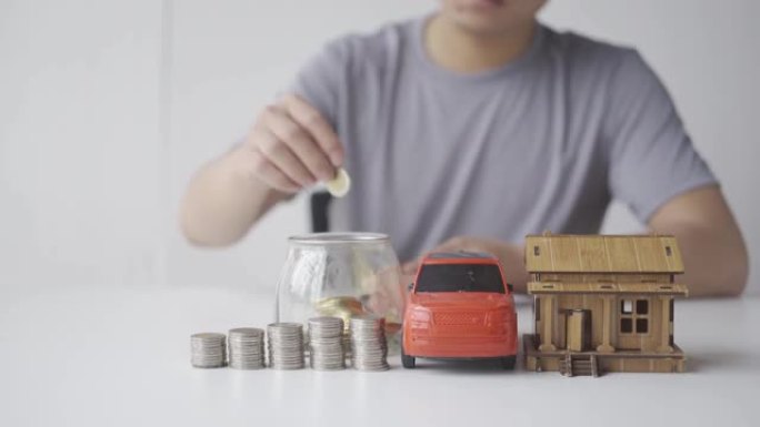 个人储蓄预算和金钱规划节俭的未来概念男性双手将欧元硬币放入存钱罐中，旁边有一辆汽车和一所房子