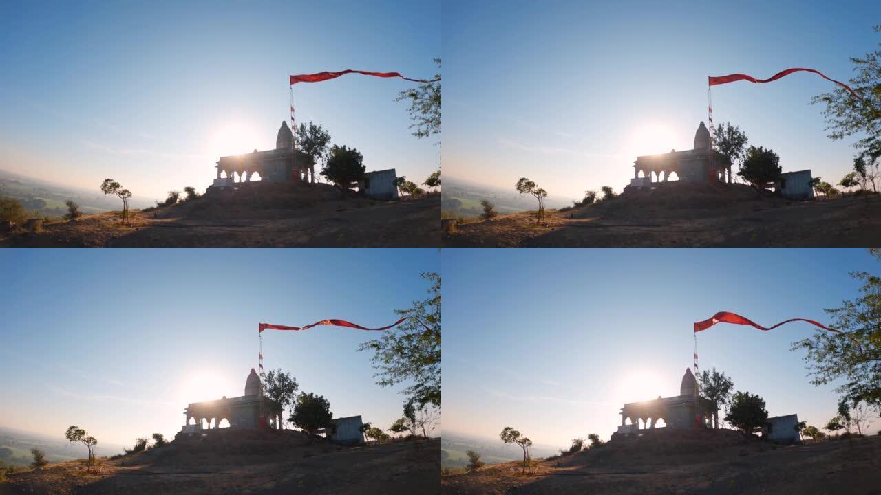 印度教古庙上橙色长旗的4k视频。灵性和冥想的概念。山上的印度古庙