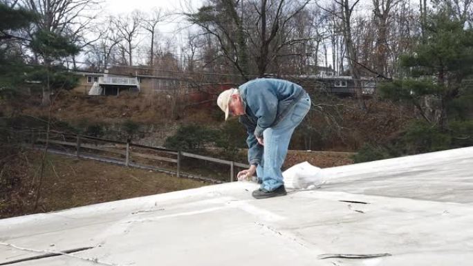 一位高级房主修理了他的平屋顶漏水的接缝胶带
