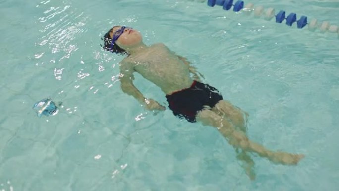 游泳池训练班: 小男孩学游泳，水面漂浮