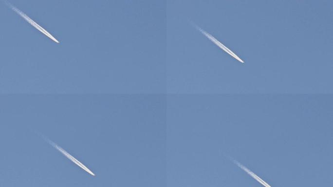飞机及其白色的踪迹在蓝天上