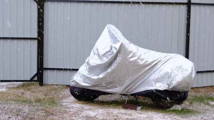 冬季户外遮阳篷下的摩托车存放。雪下的防护遮阳篷