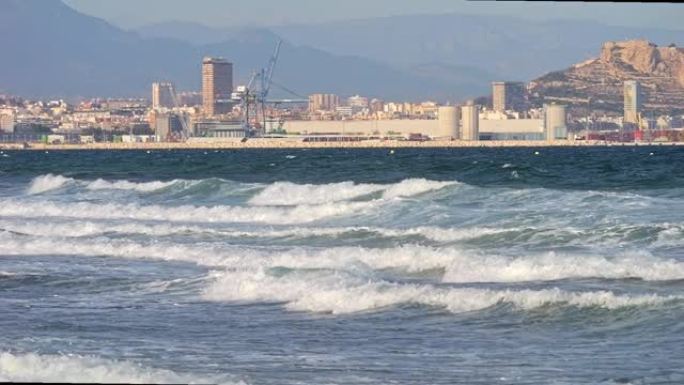 非常汹涌的大海。风暴。在晴朗的天气里，强烈的泡沫海浪撞击海岸。完美的背景。向海浪冲去。阿利坎特工业区