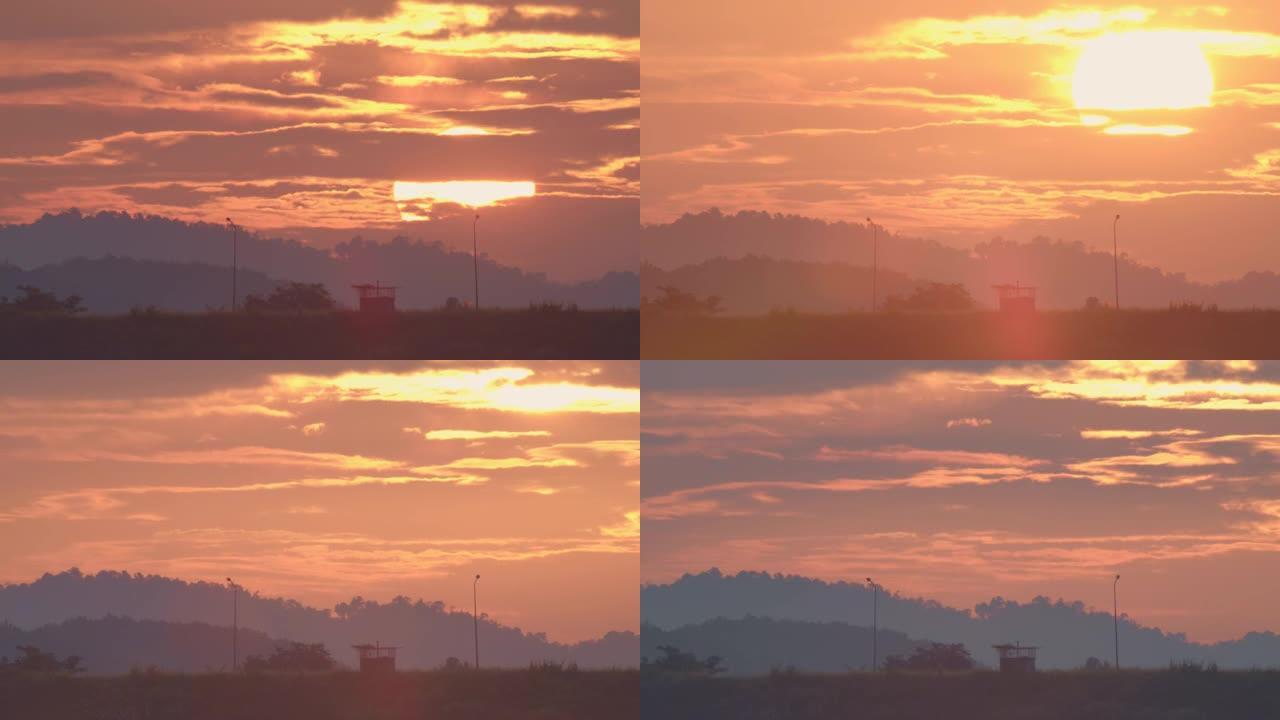 早晨黎明的标志是大太阳从地平线上方逐渐升起。在冬天的早晨，太阳在朦胧的天空和山脉中升起。自然景观上的
