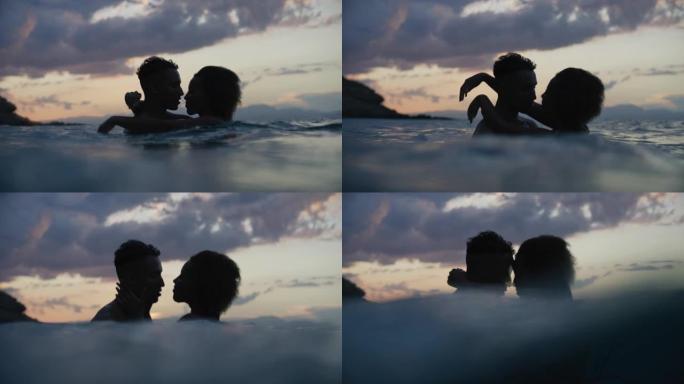 非洲民族浪漫爱情异性恋夫妇一起在黄昏时在海里游泳