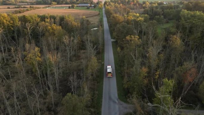 紧急消防车车辆沿乡村道路快速行驶的空中跟踪视图，带闪光灯，消防或事故警报的救援急救人员任务，周围景观