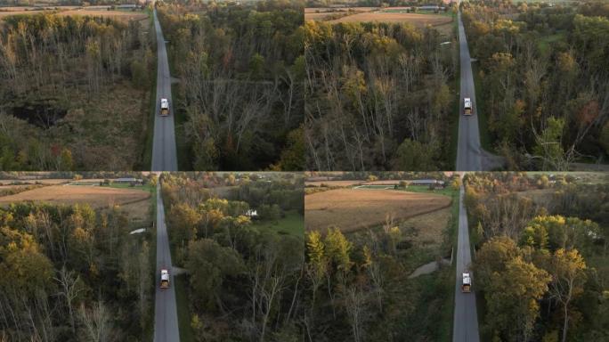 紧急消防车车辆沿乡村道路快速行驶的空中跟踪视图，带闪光灯，消防或事故警报的救援急救人员任务，周围景观